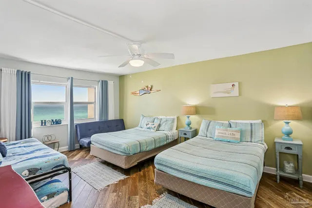 a bedroom with two beds and a large window