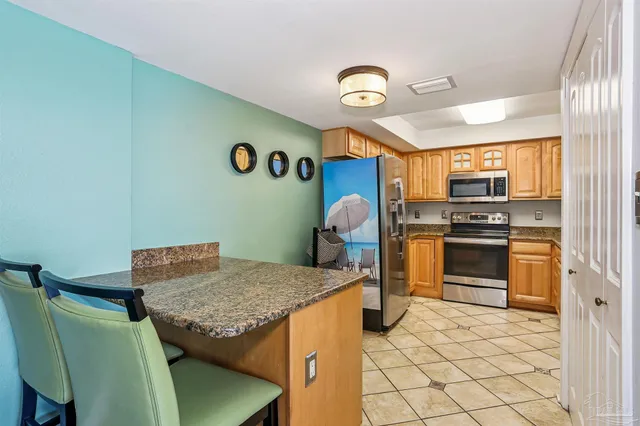 a kitchen with granite countertop a stove and a refrigerator