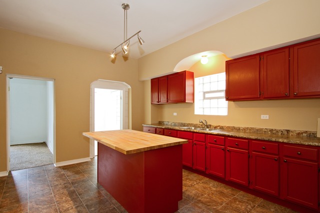 1512 South Springfield Avenue Chicago, IL 60623 - Photo 2 of 13 a kitchen with kitchen island granite countertop a sink dishwasher stove and cabinets