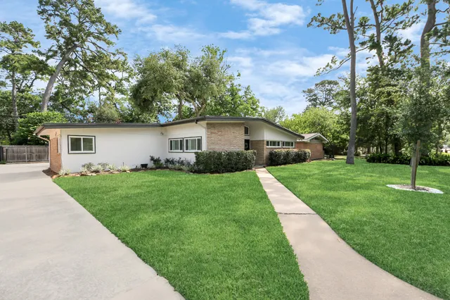 a front view of house with a yard and green space