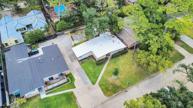 an aerial view of a house with a yard and a large tree
