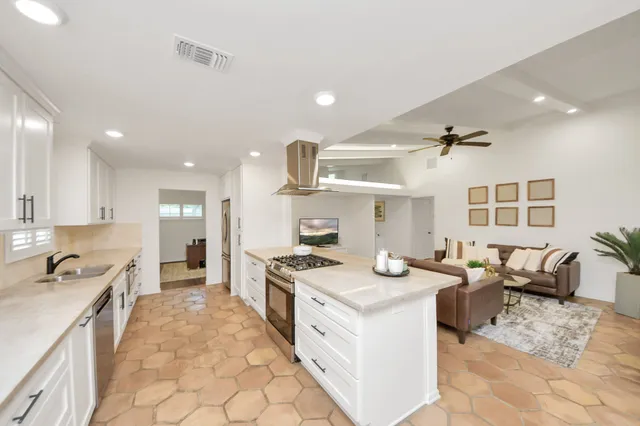 a kitchen that has a lot of cabinets in it and wooden floors