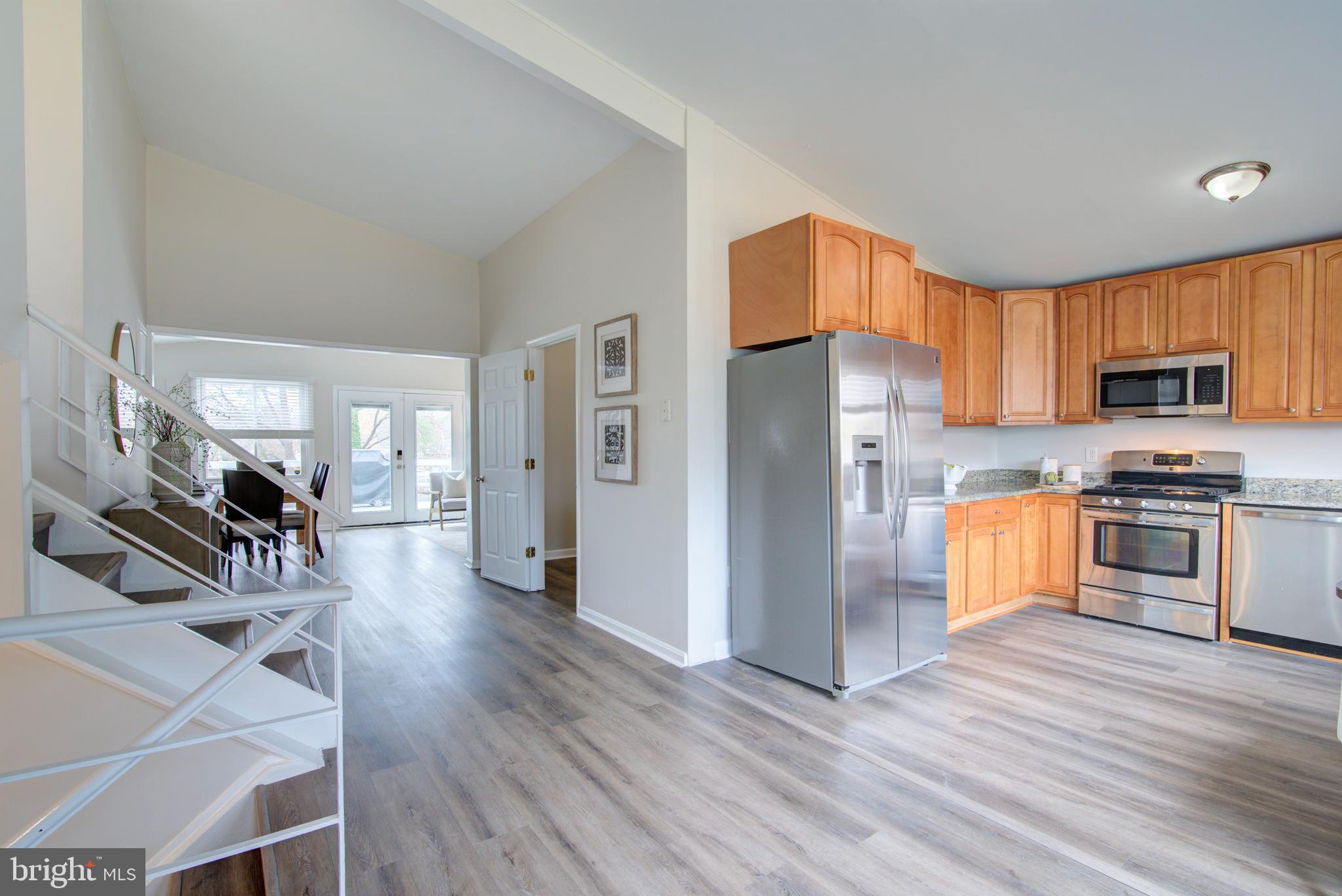 4103 Ivanhoe Lane Alexandria, VA 22310 - Photo 29 of 29 a kitchen with stainless steel appliances a refrigerator a stove a microwave a dining table and chairs with wooden floor