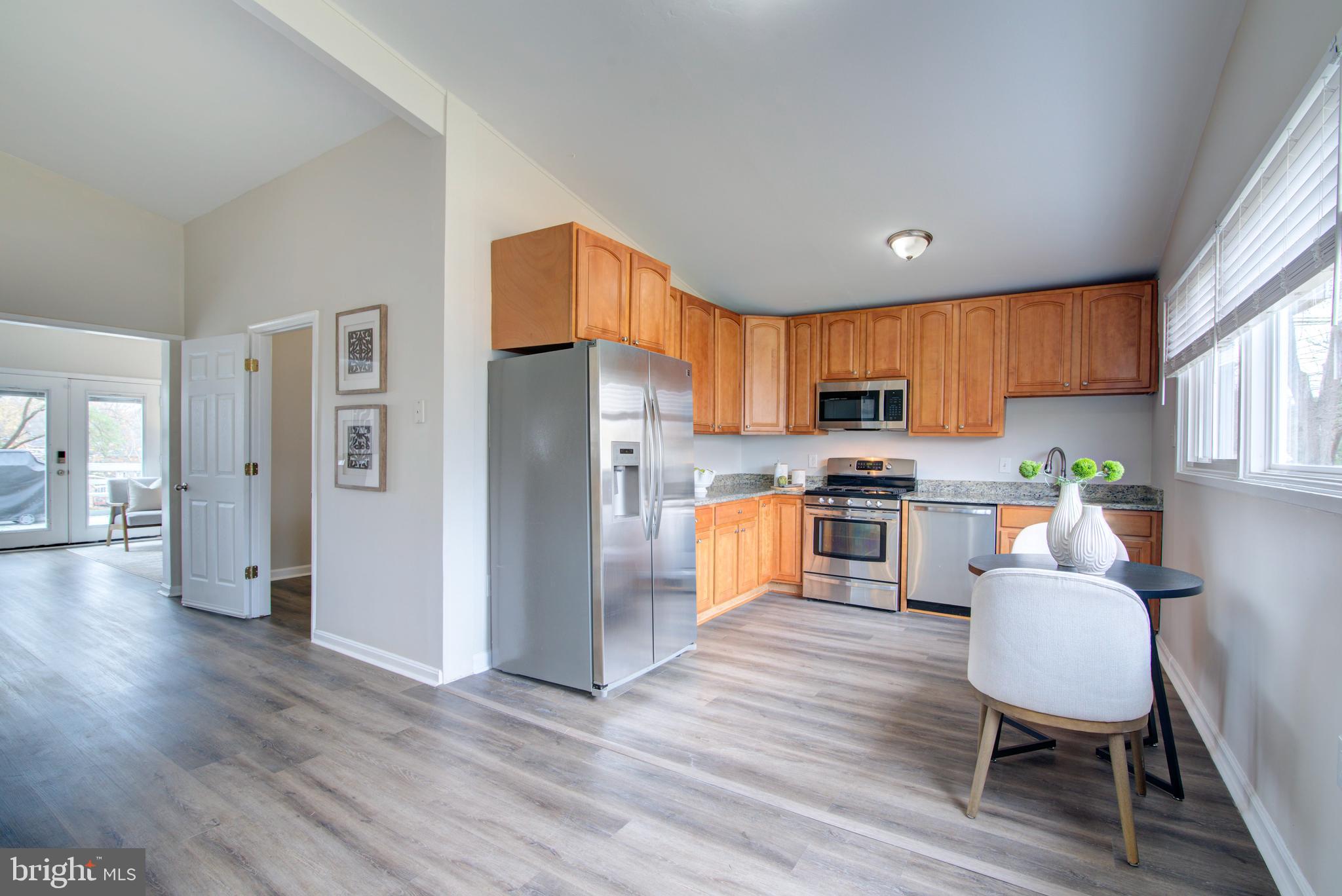 4103 Ivanhoe Lane Alexandria, VA 22310 - Photo 9 of 29 a kitchen with stainless steel appliances granite countertop a refrigerator a stove top oven a sink dishwasher and wooden cabinets