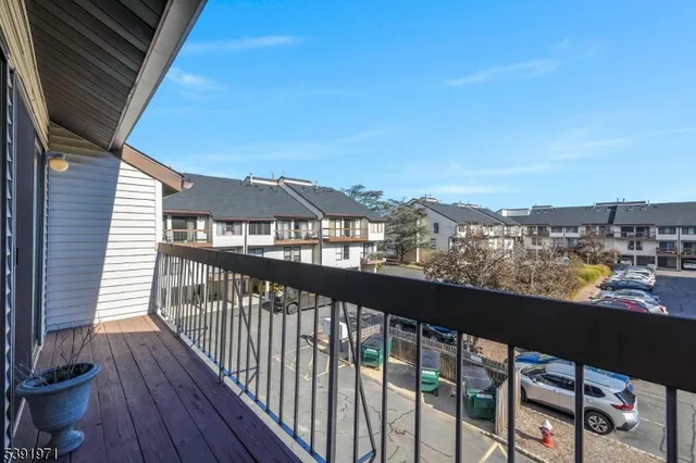 a kitchen with granite countertop a refrigerator a stove a sink dishwasher and wooden cabinets with wooden floor