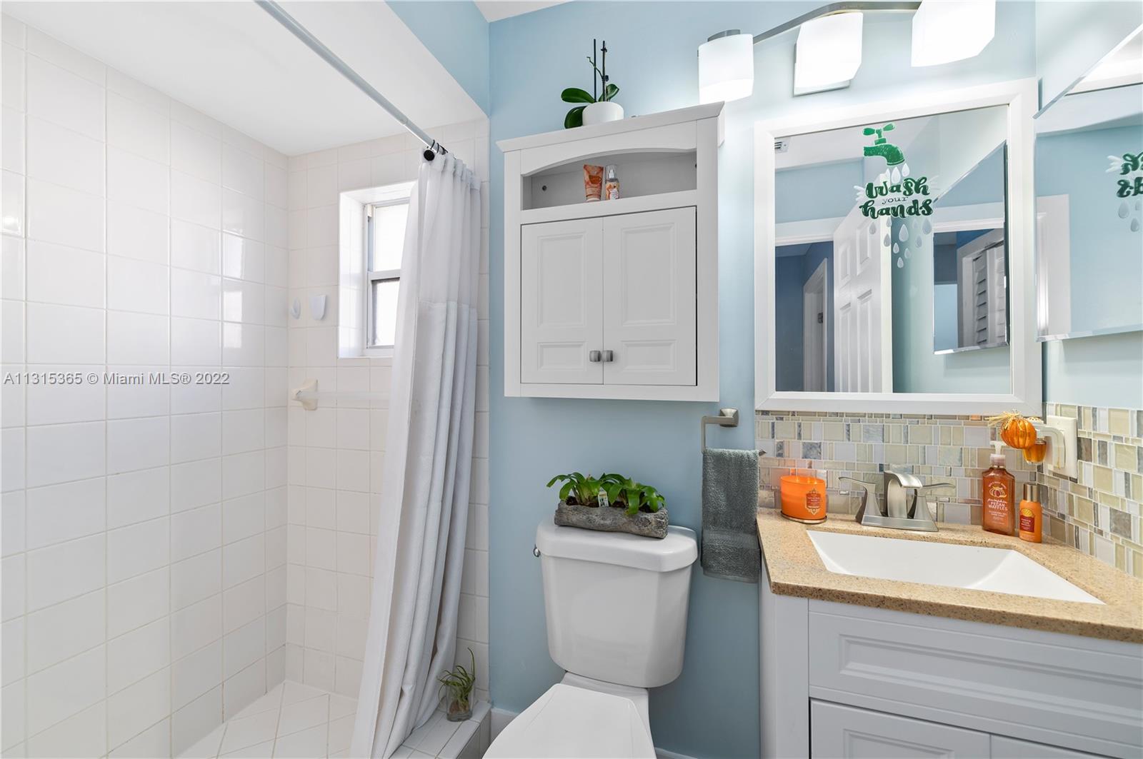 14626 Southwest 128th Court Road Miami, FL 33186 - Photo 16 of 24 a bathroom with a sink a toilet and shower curtain