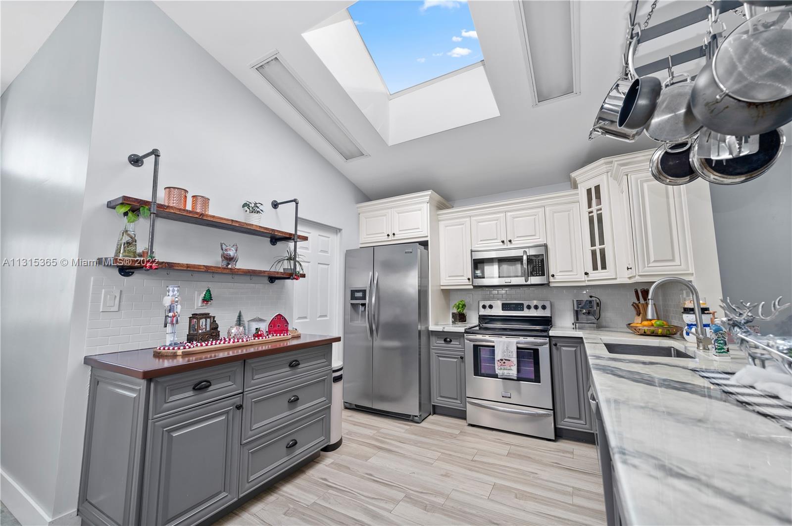 14626 Southwest 128th Court Road Miami, FL 33186 - Photo 5 of 24 a kitchen with stainless steel appliances granite countertop a sink dishwasher a refrigerator and white cabinets with wooden floor
