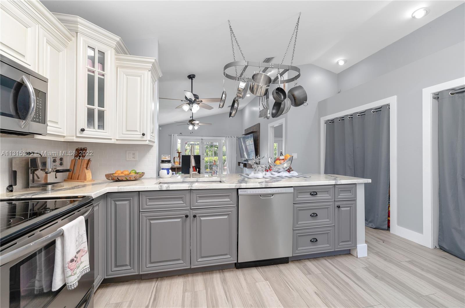 14626 Southwest 128th Court Road Miami, FL 33186 - Photo 8 of 24 a kitchen with a sink and dishwasher with white cabinets