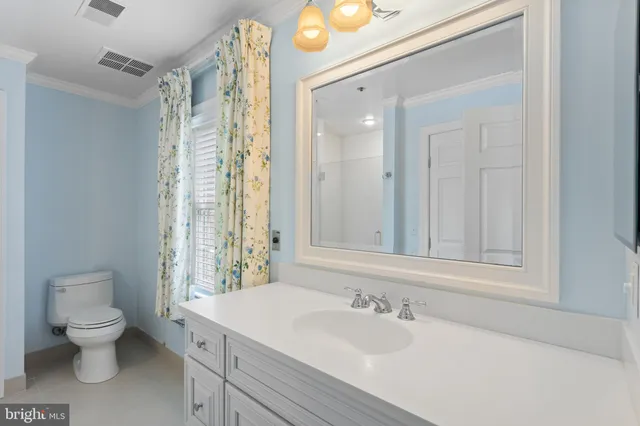 a bathroom with a sink vanity mirror and toilet