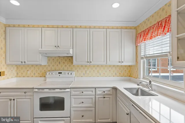 a kitchen with granite countertop white cabinets and white appliances