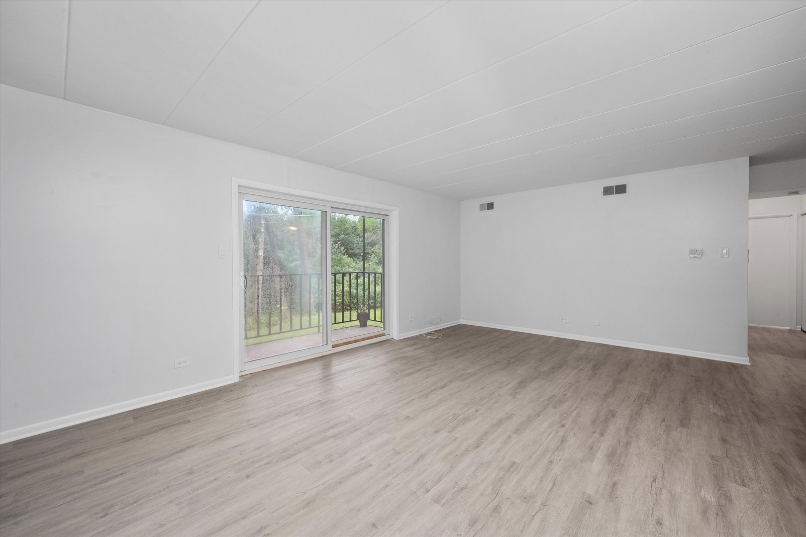 2807 Willow Road, Unit 103 Homewood, IL 60430 - Photo 5 of 21 a view of an empty room with wooden floor and a window
