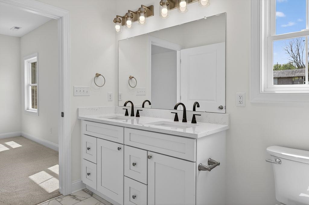 1303 East Main Street Waynesboro, VA 22980 - Photo 32 of 38 a bathroom with a sink a toilet and a mirror