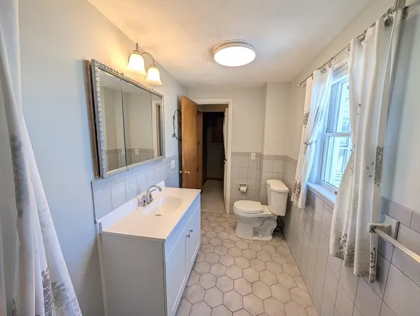 a bathroom with a sink toilet and mirror