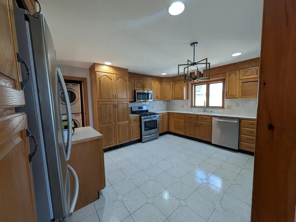 a kitchen with stainless steel appliances granite countertop a refrigerator and a sink