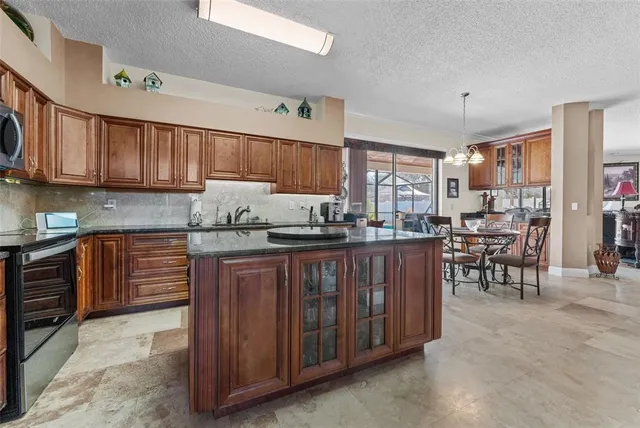 a kitchen with stainless steel appliances granite countertop a refrigerator stove top oven and sink