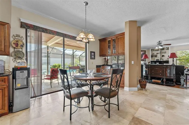 a view of a dining room with furniture a kitchen and chandelier