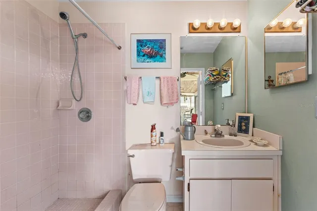 a spacious bedroom with a bed and a flat tv screen on dresser