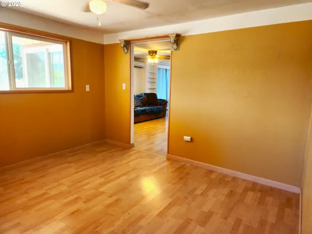 a view of a room with wooden floor and a bathroom