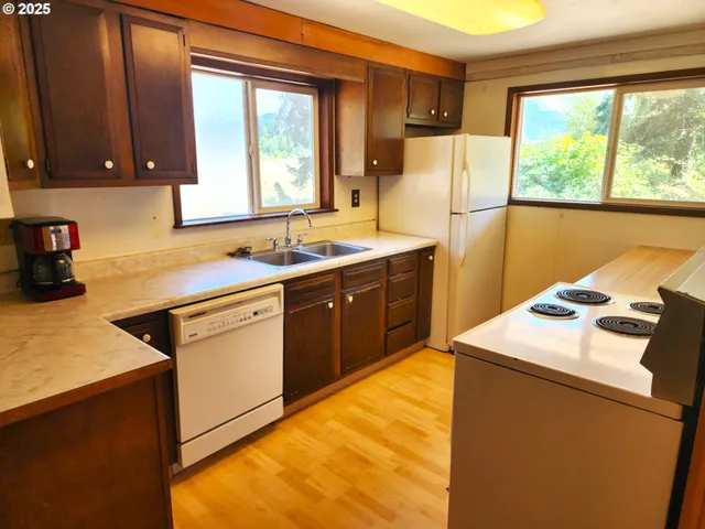 a kitchen that has a sink a stove and a refrigerator