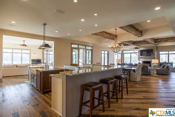 a view of a kitchen with kitchen island a counter top space a sink stainless steel appliances and cabinets