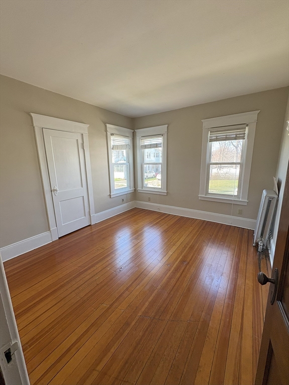 356 Springfield Street, Unit 1 Chicopee, MA 01013 - Photo 4 of 10 a view of an empty room with wooden floor and window