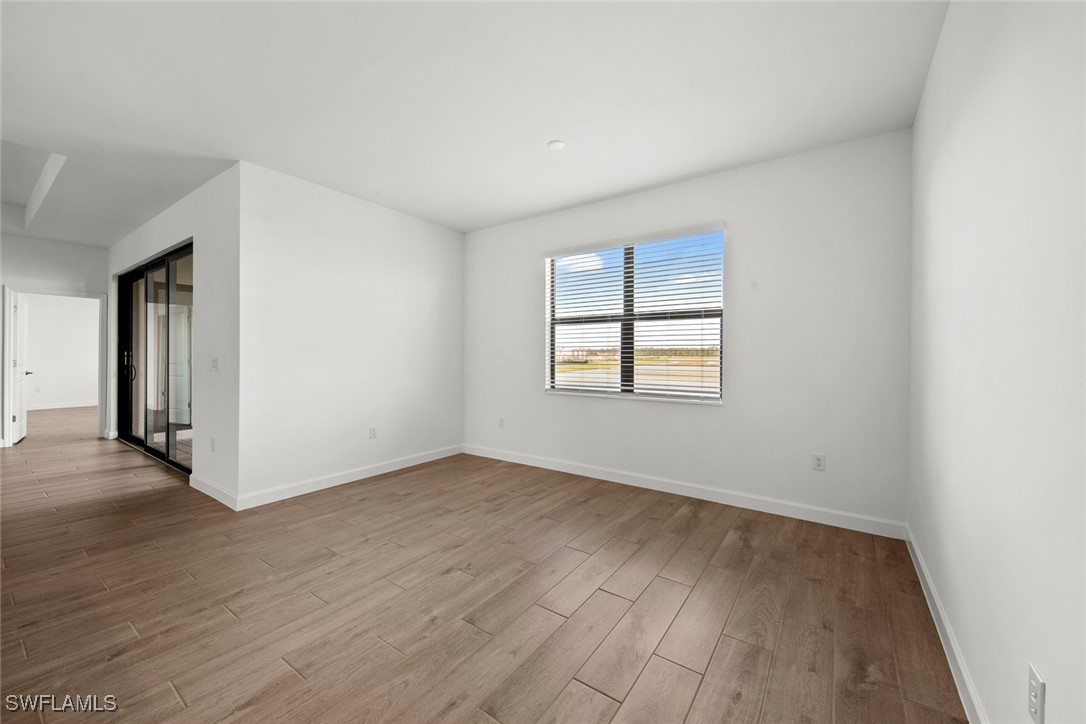 20446 Napa Loop Estero, FL 33928 - Photo 19 of 42 an empty room with wooden floor and windows
