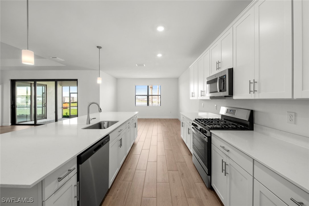 20446 Napa Loop Estero, FL 33928 - Photo 22 of 42 a large kitchen with stainless steel appliances granite countertop a lot of counter space and wooden floor