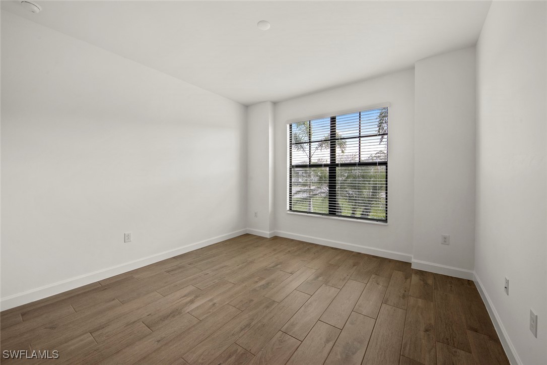 20446 Napa Loop Estero, FL 33928 - Photo 9 of 42 an empty room with wooden floor and windows