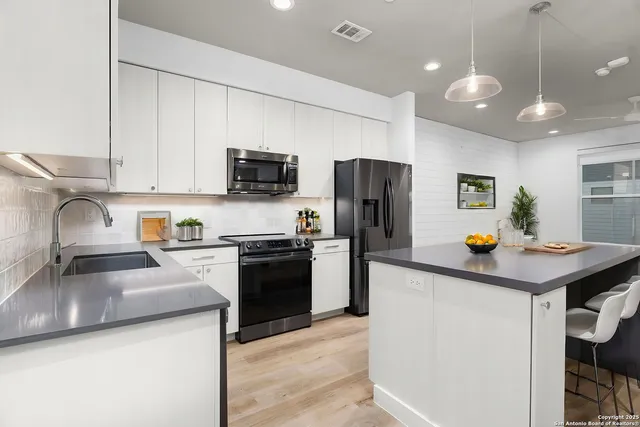 a kitchen with a refrigerator a sink a stove and cabinets