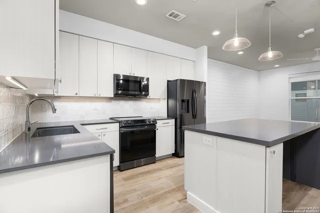 a kitchen with kitchen island stainless steel appliances a sink stove and refrigerator