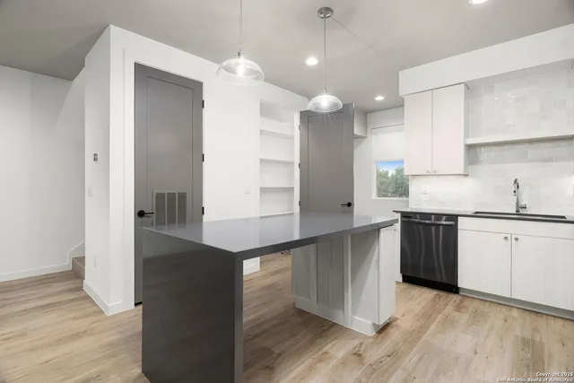 a kitchen with stainless steel appliances granite countertop a refrigerator a sink and a stove