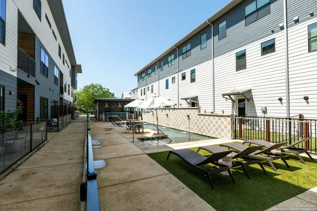 a view of a patio with couches table and chairs with wooden floor and fence