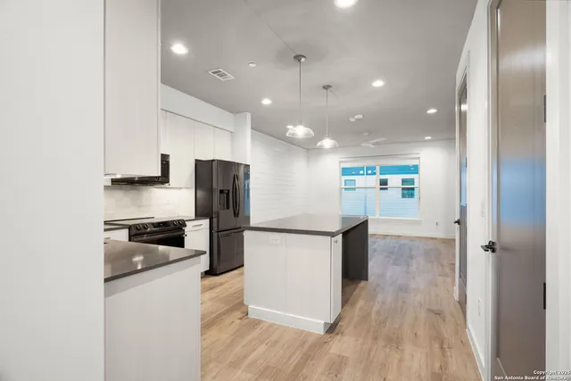 a kitchen with stainless steel appliances granite countertop a refrigerator and a stove top oven