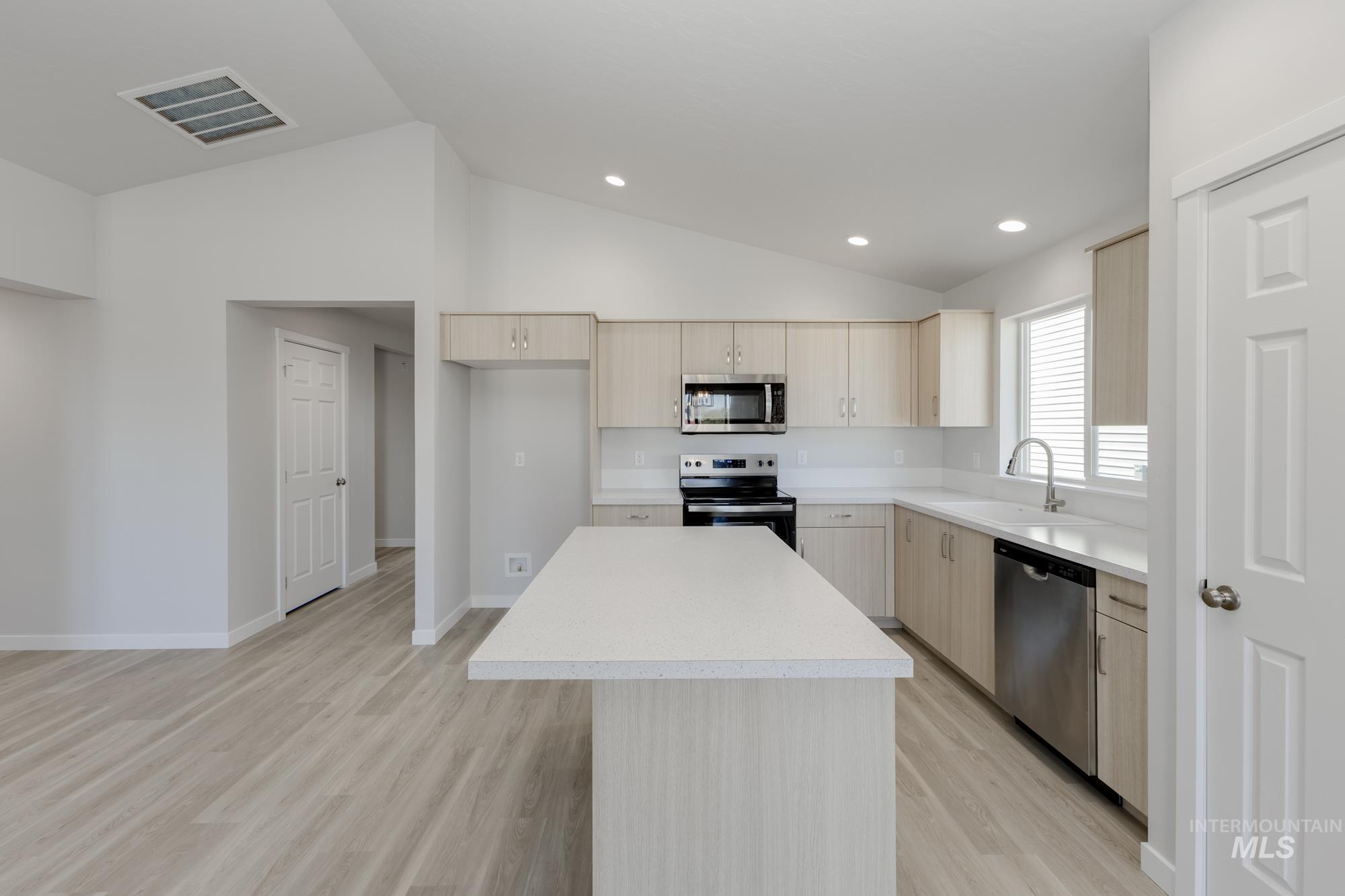 13337 Scrape Street Caldwell, ID 83607 - Photo 8 of 19 Kitchen featuring a center island with solid surface countertops, stainless steel appliances, wood-finish cabinetry, and recessed lighting