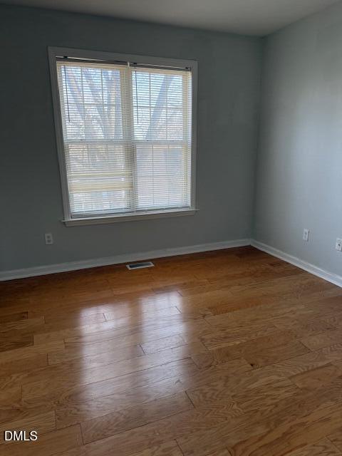 2036 Turtle Point Drive Raleigh, NC 27604 - Photo 22 of 27 an empty room with wooden floor and windows