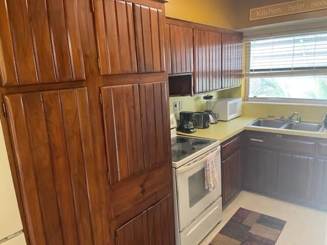 a kitchen with a sink a stove cabinets and wooden floor