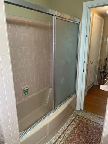 a bathroom with a shower and a glass door
