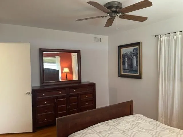 a bedroom with a bed and a mirror on the dresser