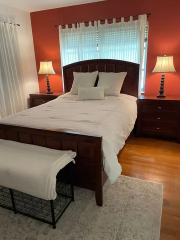 a bed sitting in a bedroom next to a lamp