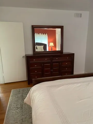 a bedroom with a bed and a mirror on dresser