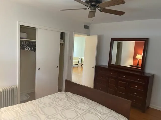 a bedroom with a bed and a mirror on the dresser