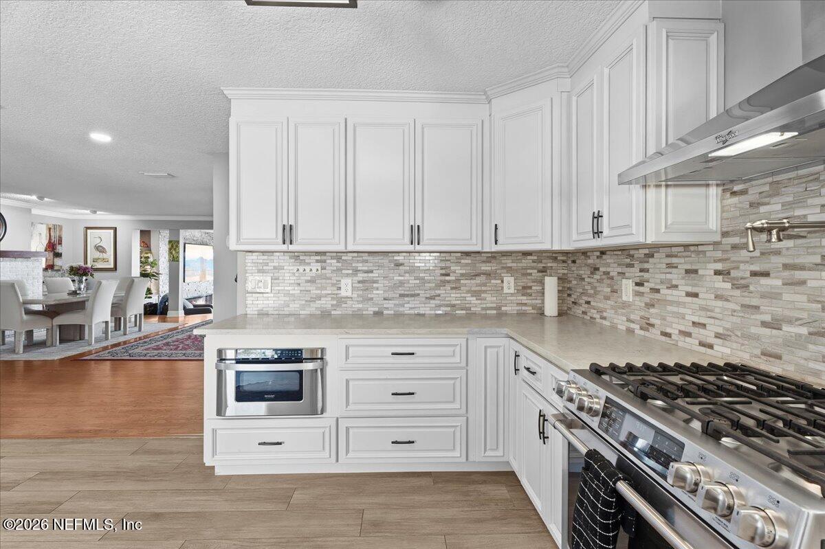 6215 West Shores Road Fleming Island, FL 32003 - Photo 26 of 103 a kitchen with granite countertop a stove a sink and a white cabinets