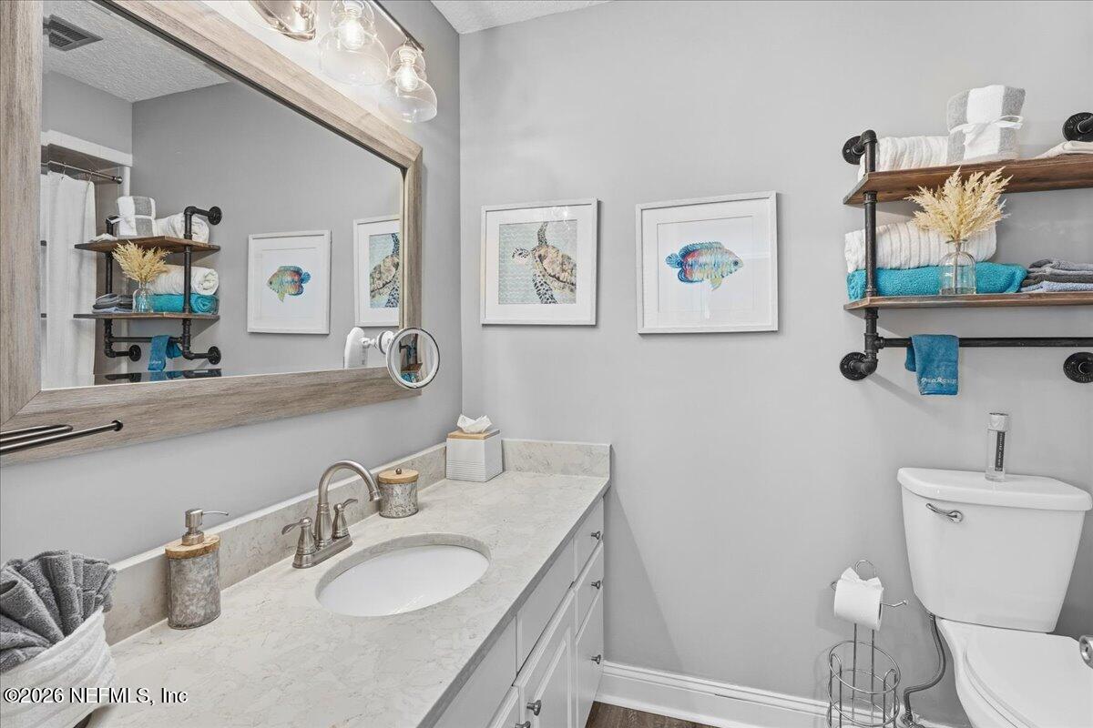 6215 West Shores Road Fleming Island, FL 32003 - Photo 38 of 103 a bathroom with a granite countertop toilet sink and mirror