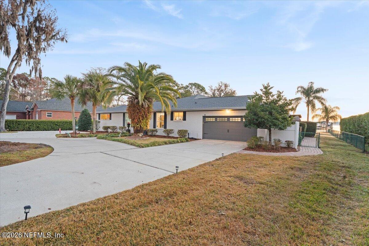 6215 West Shores Road Fleming Island, FL 32003 - Photo 10 of 103 a view of a white house with a swimming pool and a yard