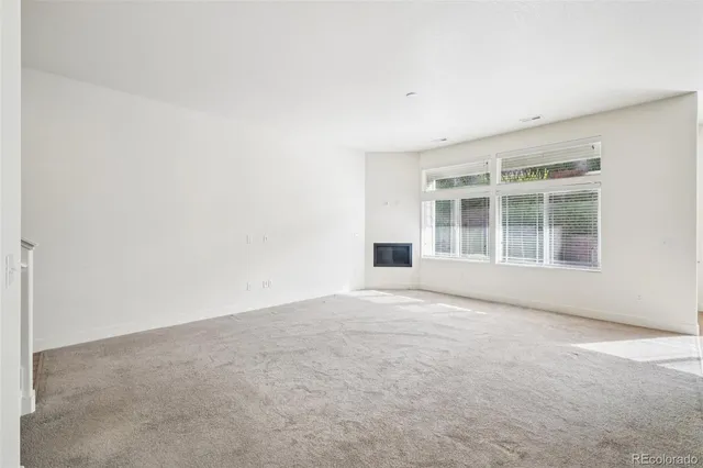 a large kitchen with stainless steel appliances a large counter top a refrigerator and a sink