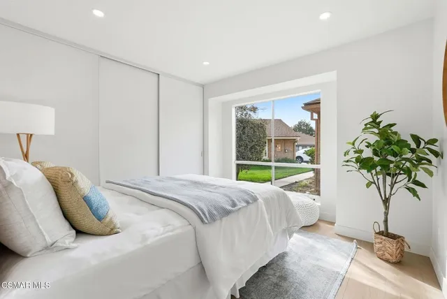 a bed sitting in a bedroom next to a window