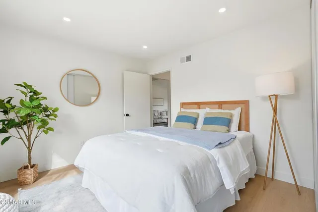 a bedroom with bed and a potted plant