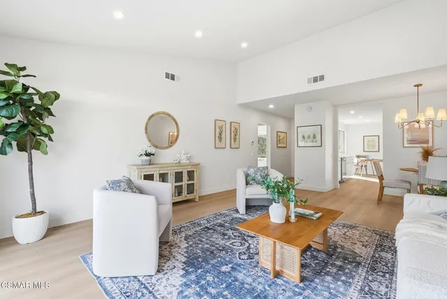 a living room with furniture a chandelier and a table
