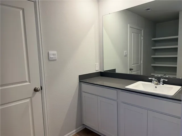 a bathroom with a granite countertop sink and a mirror