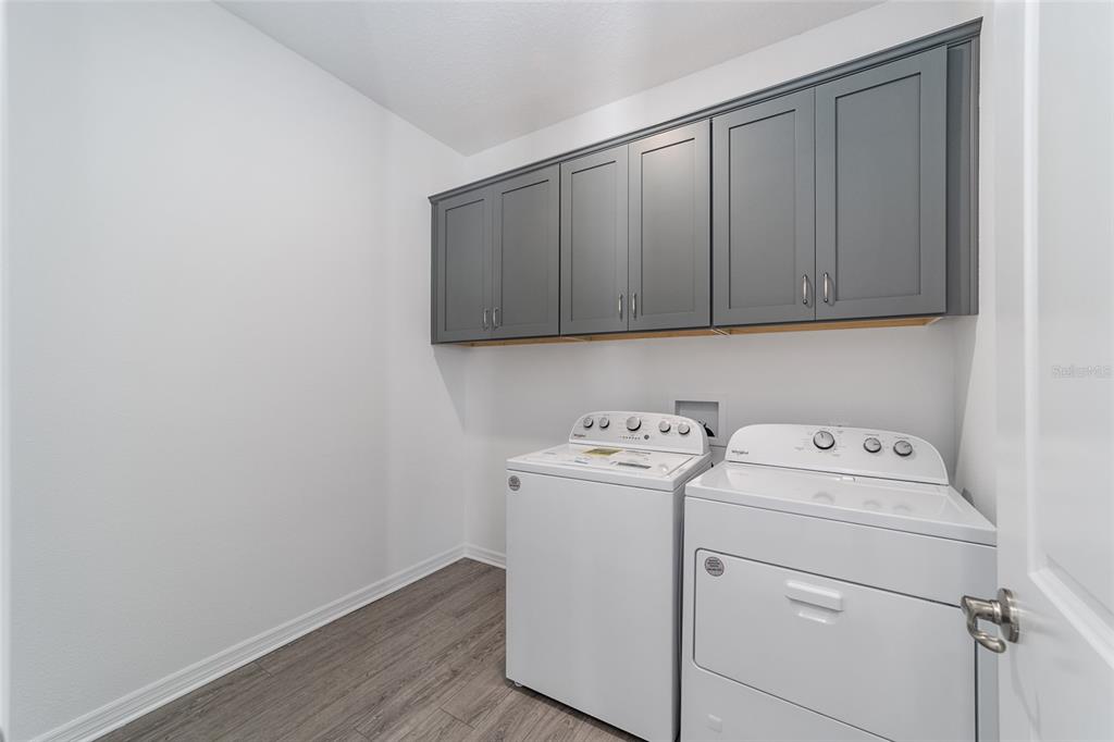 7232 Southwest 63rd Street Ocala, FL 34474 - Photo 11 of 54 a view of washer and dryer with wooden cabinet